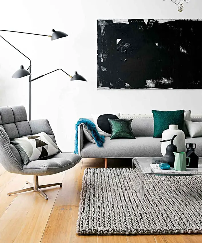 Salon clair avec canapé design gris clair et coussins bleu turquoise