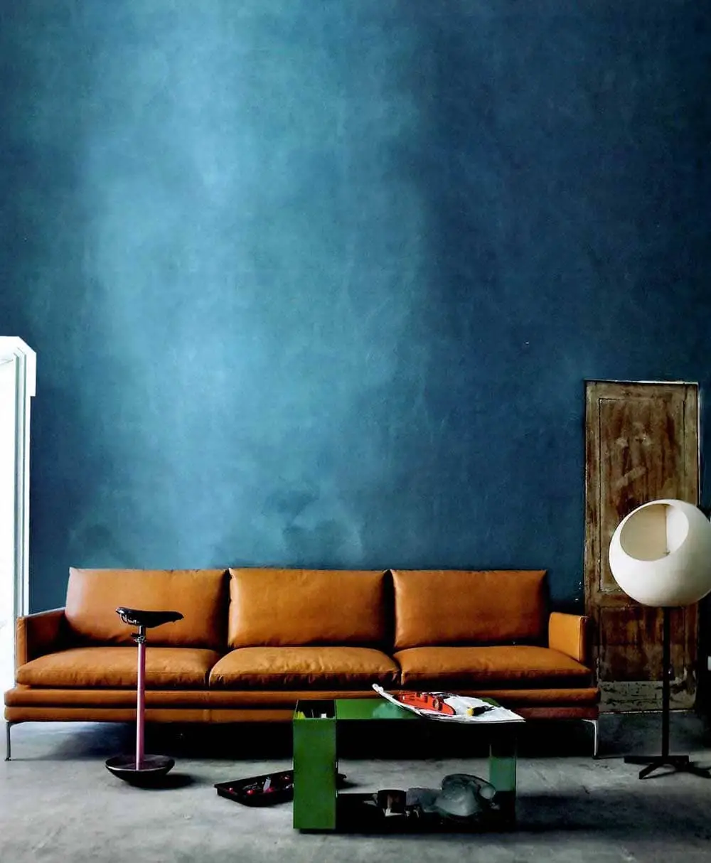 Salon design chic avec canapé cuir avec murs bleu